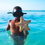 Kid playing in the ocean, observing water safety rules