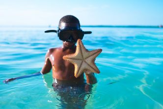 Kid playing in the ocean, observing water safety rules