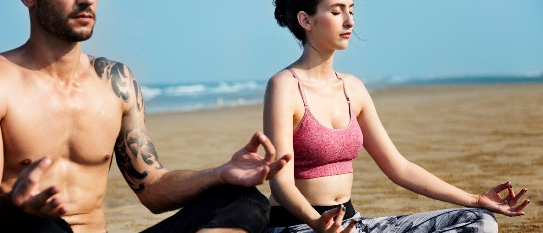Man and Woman Meditating on a Beach