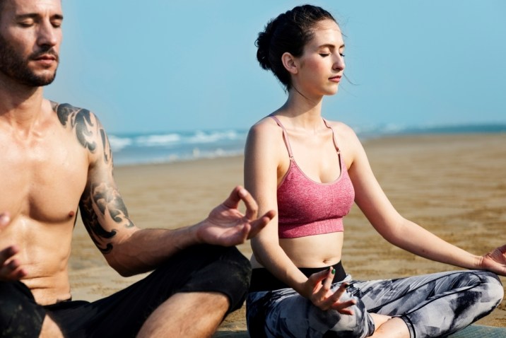 Man and Woman Meditating on a Beach