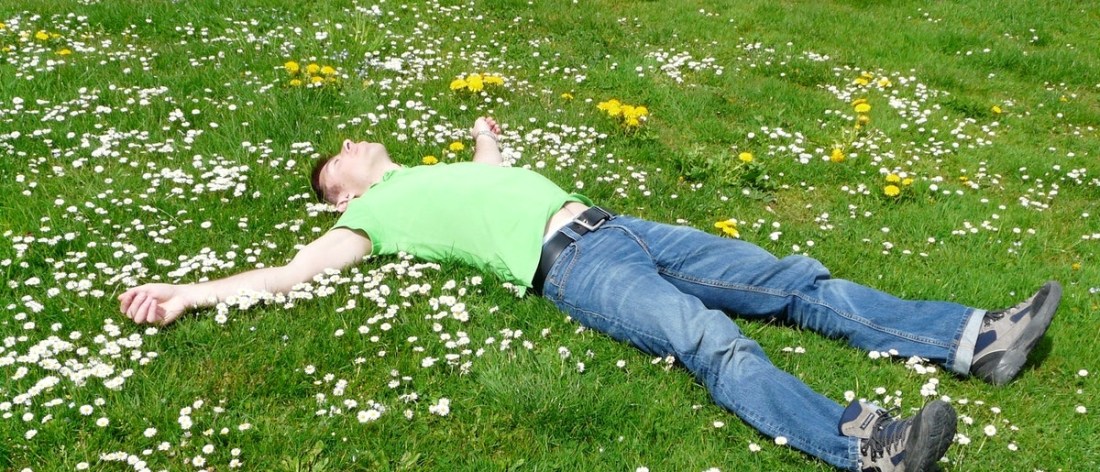 Man laying in field experiencing calm still mind