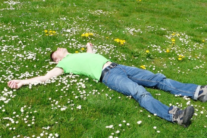 Man laying in field experiencing calm still mind