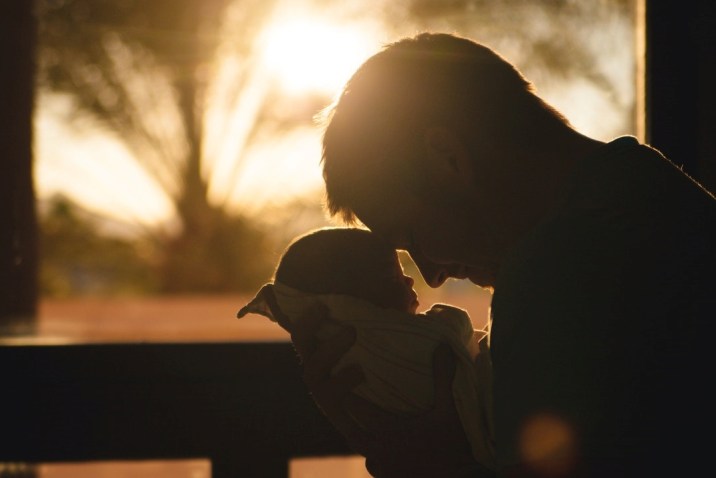 Man holding and selflessly loving a baby